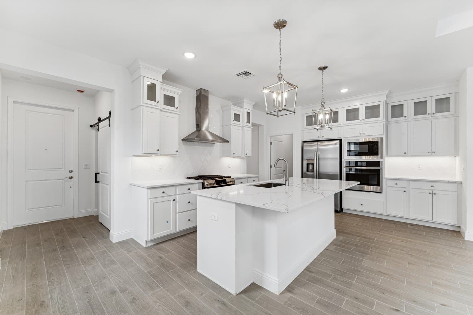 Kitchen with stacked glass-front upper cabinets