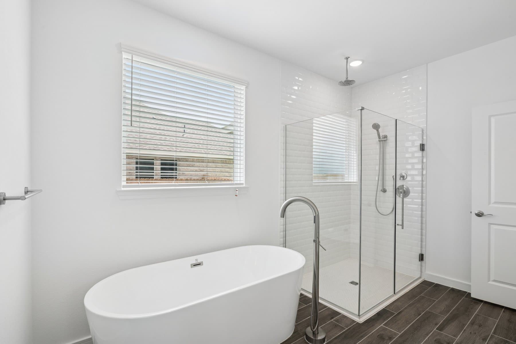 Primary bath featuring glass shower enclosure & freestanding tub