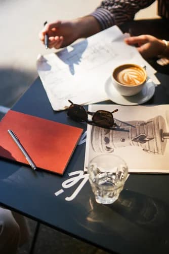 Interiors Team Working at Cafe Kitsune In West Village with Red Notebook