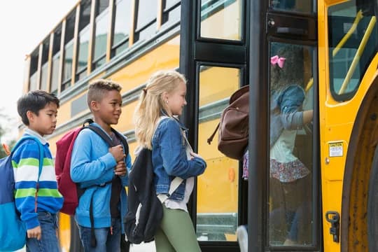 Diverse group of children boarding a school bus
