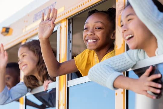 School children wave from school bus