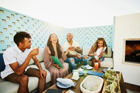 Wide shot of laughing family sharing drinks at outdoor restaurant