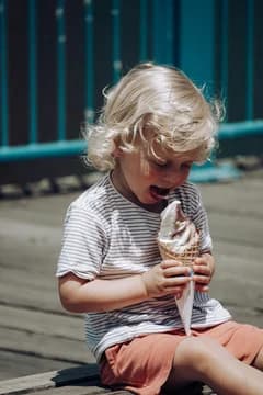 Blond Toddler Eating an Ice Cream Cone on the Boardwalk