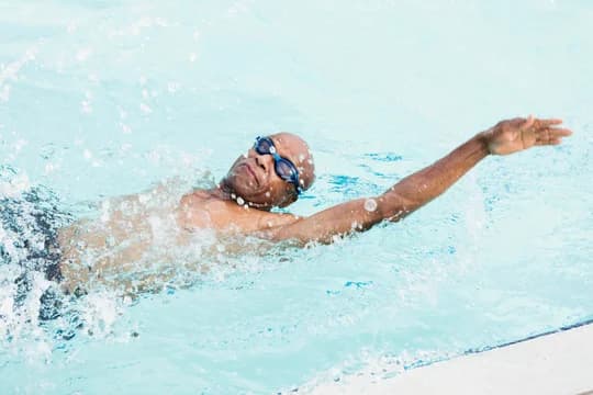 Older Man Swimming Laps in Pool