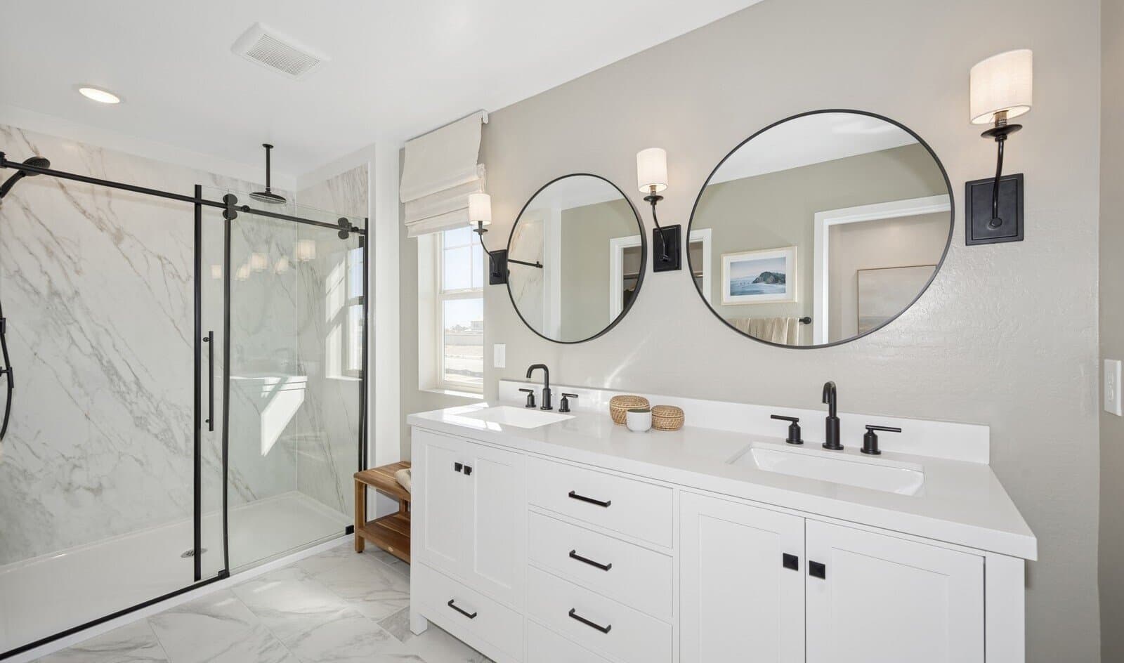 Primary bath with dual circular mirrors and matte black fixtures